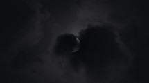 Moon in first quarter covered by atmospheric clouds