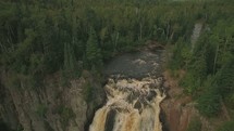 aerial view over a river and waterfall 