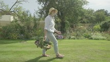 Happy joyful senior caucasian woman twirling walking through her garden themes of retirement gardening active senior carefree
