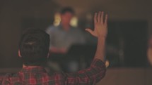 Audience with hands raised at a worship concert.
