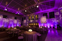 Restaurant and stage lit with purple lights and snowflake design Christmas holiday event party