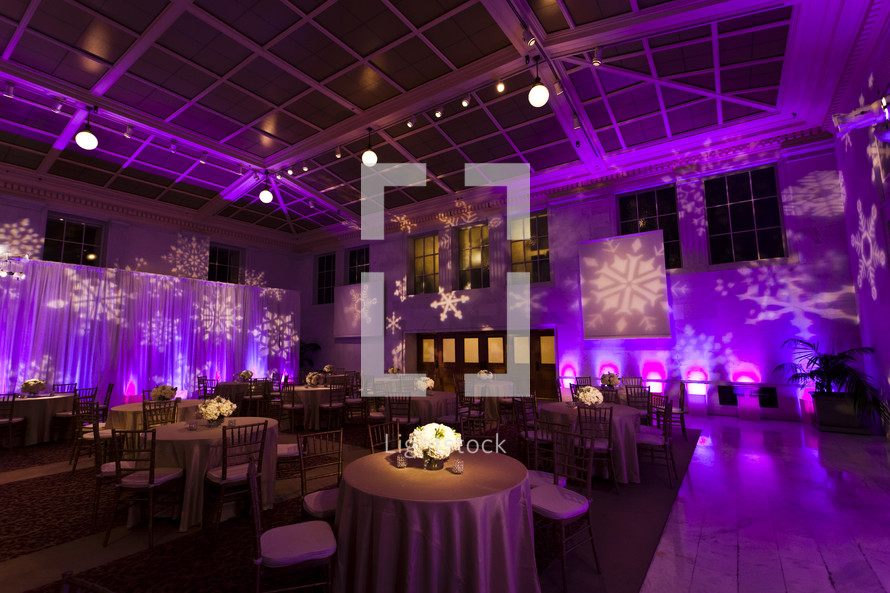 Restaurant and stage lit with purple lights and snowflake design Christmas holiday event party