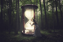 woman touching a giant glowing hourglass
