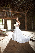 bride standing in an old barn