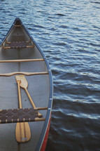 canoe with paddles floating on water 