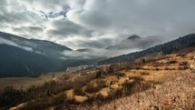 Mountain rural landscape, high clouds cover the top of the mountain, autumn gloomy weather