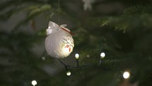 Christmas background with white sparkling ball on Christmas tree with lighting