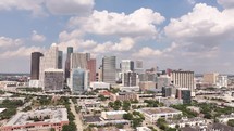 Aerial video of downtown Houston, Texas on a beautiful blue sky cloudy day with tall buildings in the background.