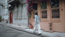 Back view of young girl walking happily through a cozy residential street