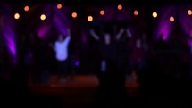 worship leaders on a dark stage singing 