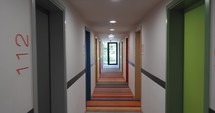 Steadicam view of a deserted hotel corridor with striped carpet