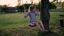 a happy child on a swing outdoors 