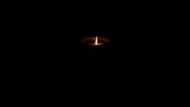 flickering flame from a candle in darkness 