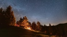 Magic stars sky with milky way galaxy in wild forest nature and friends sitting over campfire in starry night astronomy Time-lapse
