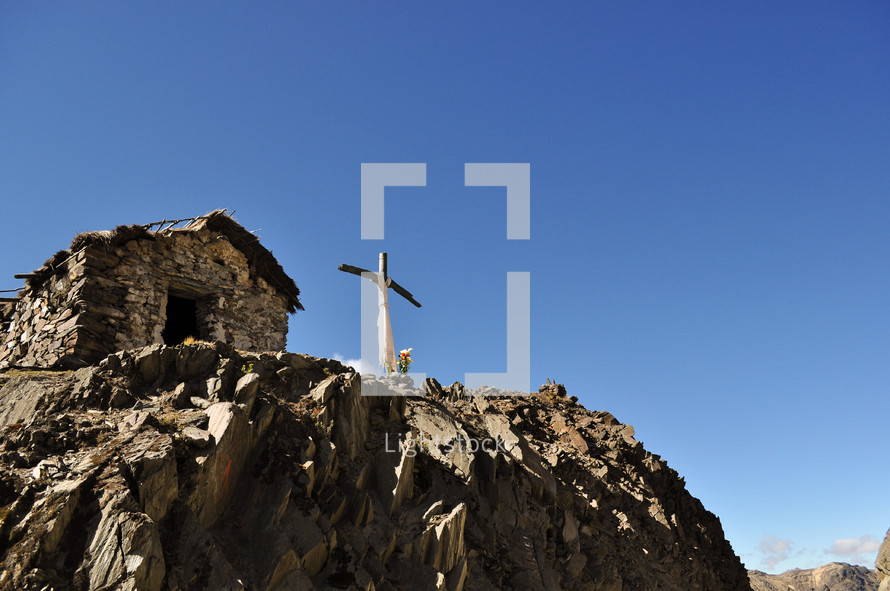 a cross shrine on a rocky peak 