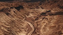 Winding gravel road surrounded by rocky hills in Death Valley