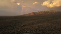 Aerial of a rainbow next to majestic mountains