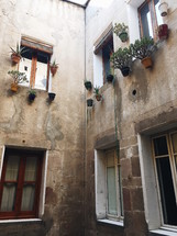 flower pots by windows on the exterior of buildings in Barcelona 
