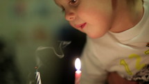 Little boy blowing out the candles