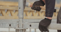 Construction worker carrying scaffolding in a construction site