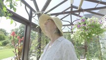 Senior caucasian woman gardening in her greenhouse themes of retirement seniors gardening hobbies
