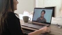 a young woman working from home on a video conference 