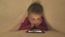 child watching a movie on a tablet 