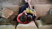 a mother reading a book to her son 