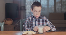 Boy drinking a glass of milk at home
