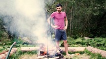 man standing by a campfire 