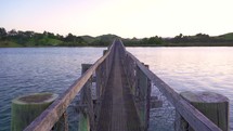Peaceful evening colors over wooden bridge over water river bay in New Zealand nature