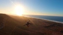 Fly like a bird on paragliding wing at beautiful sunset in Ocean coast, Freedom of free flight
