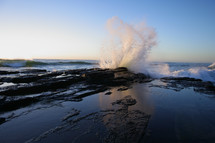 powerful waves crashing into rocks on a shore