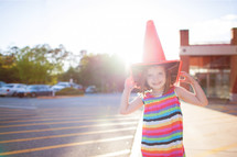 girl child acting silly with a traffic cone on her head 