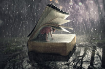 A man finds safety under the pages during a rain storm.