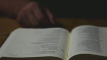 a man reading a Bible and closing it 