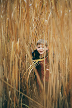 a boy hiding in a field 