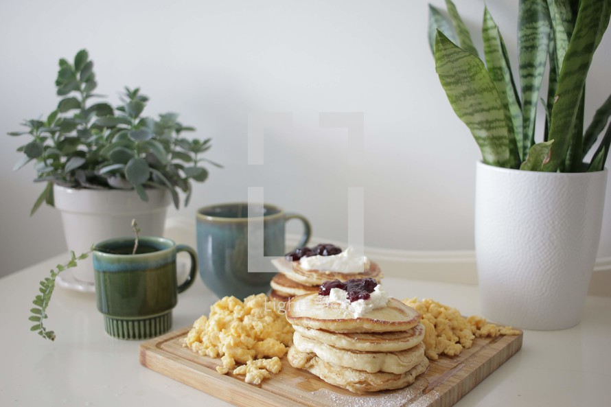 Pancake and egg breakfast with tea and plants
