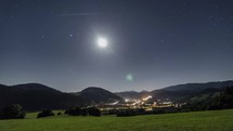 Starry night sky with moon light over rural country Time lapse
