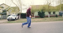 Old man running down a street 