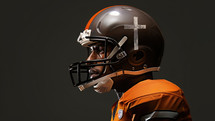 Team Jesus. 3D rendering of an American football player wearing an orange uniform with a cross on a dark background.