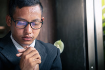 Close up young christian man praying. copyspace