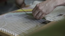 woman weaving on a loom 