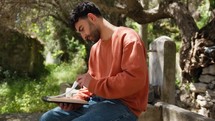 Philosopher Boy Thinks Seated Under The Olive Tree With Pencil And Notebook