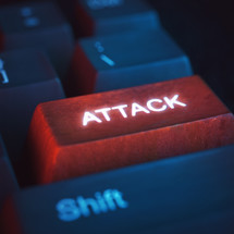red attack key on a keyboard used to hurt other people online.