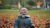a toddler boy playing in fall leaves 