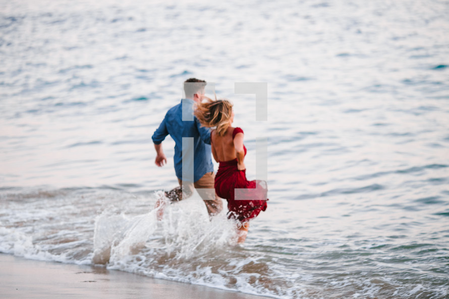 couple running into the ocean 