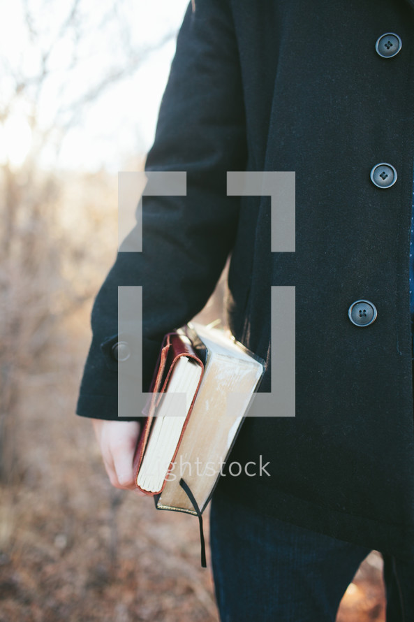 man carrying a Bible and journal at his side 