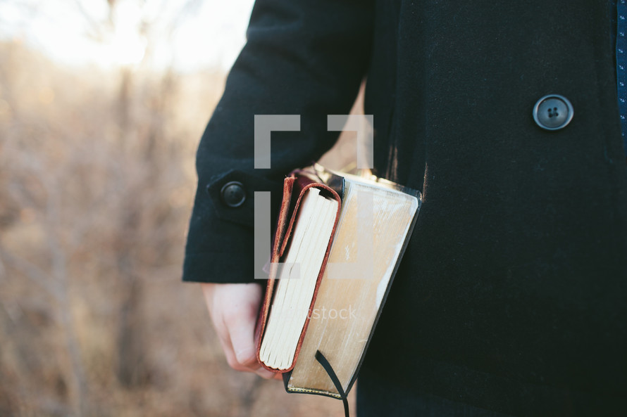 man carrying a Bible and journal at his side 