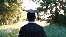 a graduated walking down a country path 
